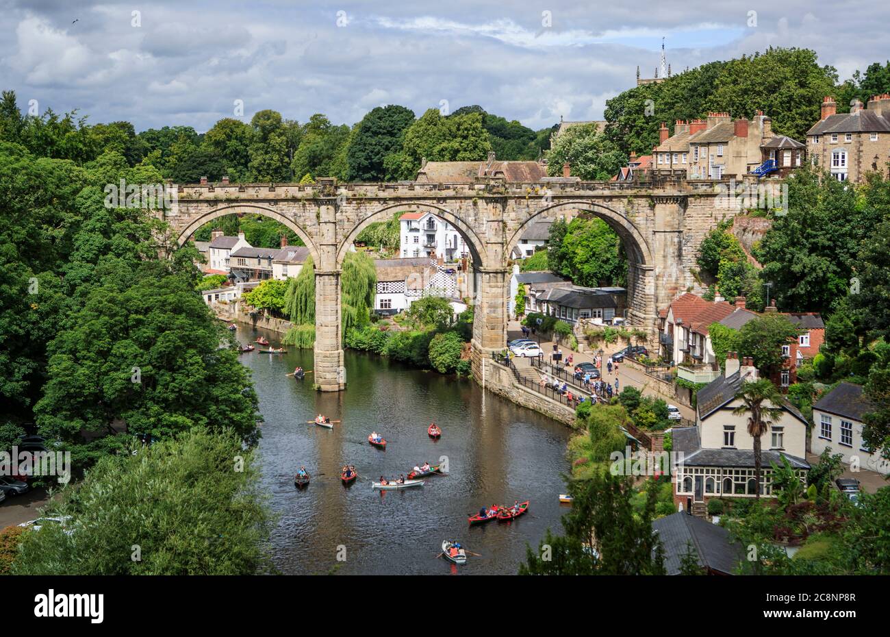 Les gens sont à la parée de bateaux de location car ils apprécient le temps d'été sur la rivière Nidd, sous le Viaduc de Knaresborough dans le North Yorkshire. Banque D'Images