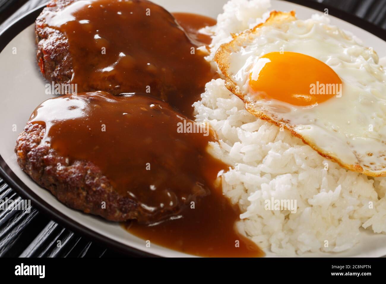 Plat hawaïen classique, le Loco Moco se compose de riz cuit à la vapeur avec steak de hamburger juteux, œuf frit et fumé dans une sauce savoureuse, sur une assiette Banque D'Images