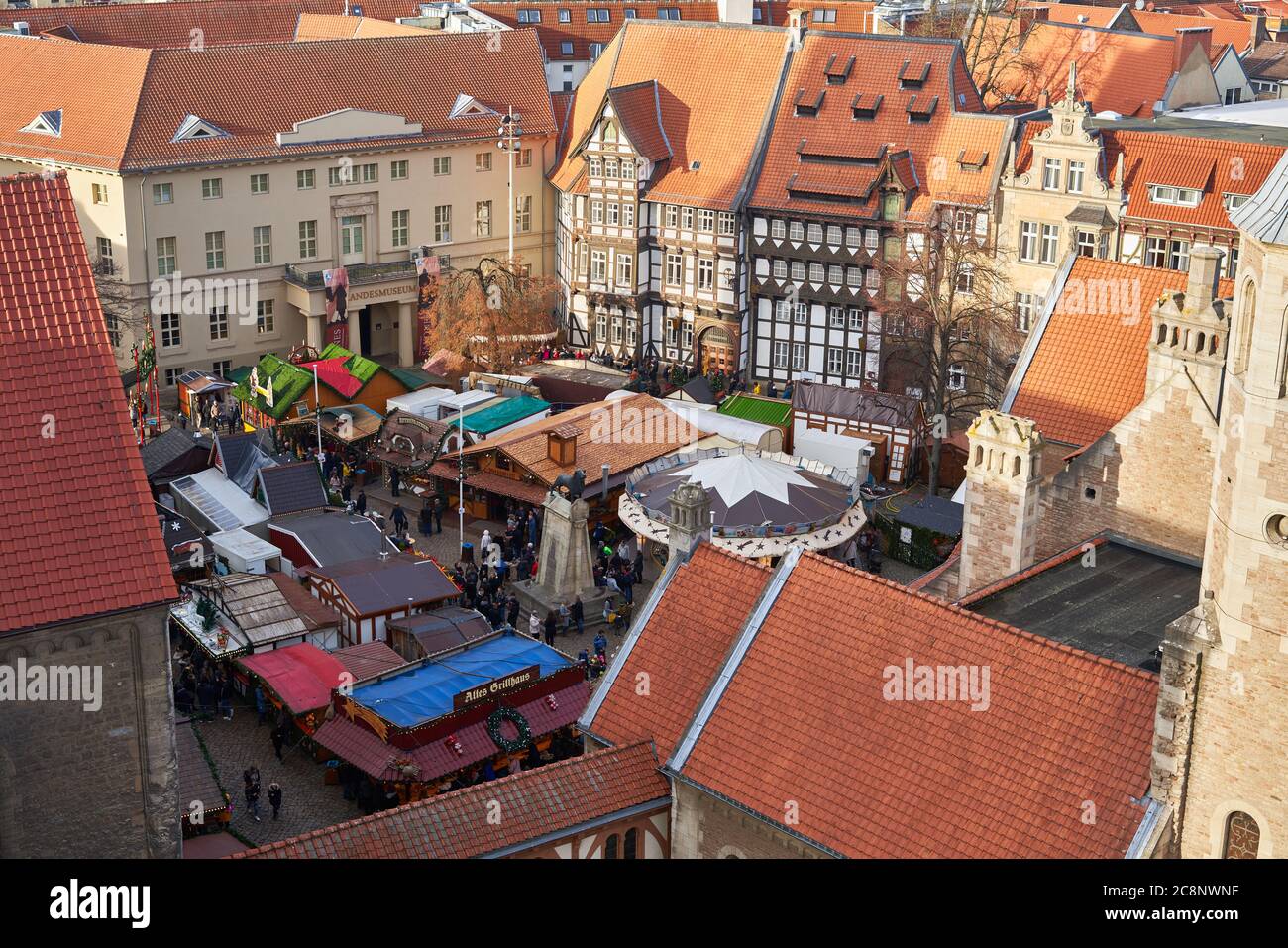 Marché de Noël de Braunschweig, Basse-Saxe, Allemagne. Au-dessus des toits rouges de la vieille ville historique avec la statue du lion de Brunswick et des maisons à colombages. Banque D'Images