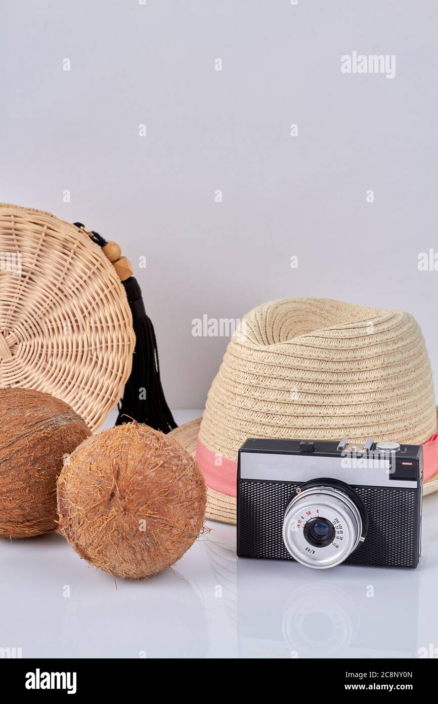 Composition d'un appareil photo vintage avec chapeau de paille et noix de coco. Banque D'Images