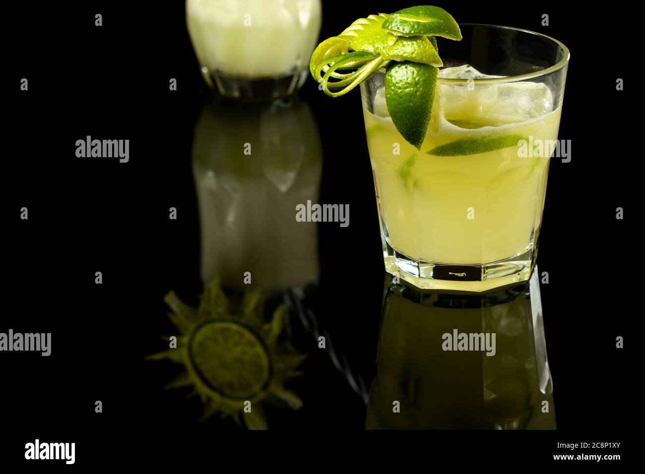 CAIPIRINHA DE CITRON UNE BOISSON TYPIQUEMENT BRÉSILIENNE, PHOTOGRAPHIÉE SUR UNE TABLE EN VERRE SOMBRE Banque D'Images