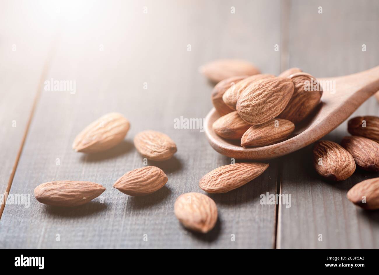 Amandes noix pelées dans une cuillère à bois sur une table en bois. Les amandes sont des noix très populaires et des protéines élevées. Nourriture saine. Banque D'Images