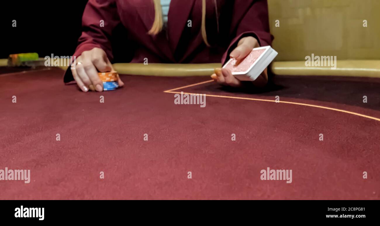 Séance concessionnaire dans un casino à la table tout en maintenant les cartes et la distribution Banque D'Images