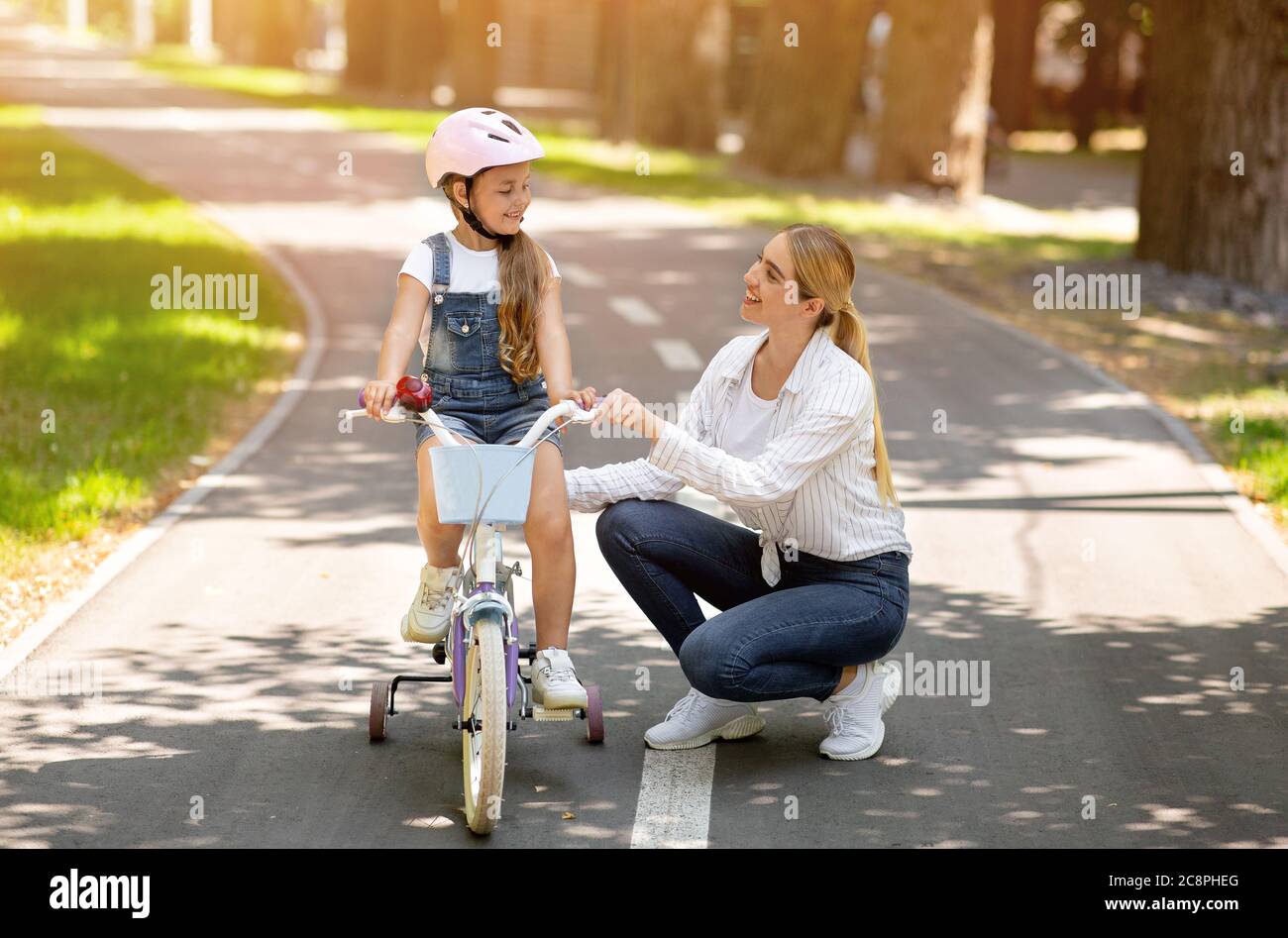 Mère enseignement fille de faire du vélo dans le parc Banque D'Images