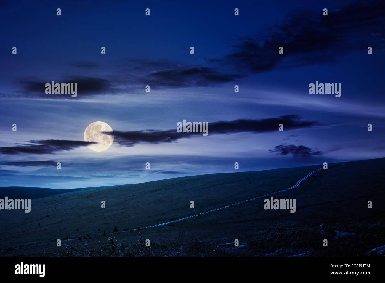voyagez dans les montagnes carpathes en été la nuit. route à travers les prairies verdoyantes au loin en pleine lune. paysage idyllique avec des nuages Banque D'Images voyagez dans les montagnes carpathes en été la nuit. route à travers les prairies verdoyantes au loin en pleine lune. paysage idyllique avec des nuages Banque D'Images
