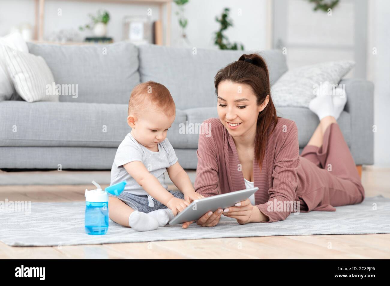 Jeune maman et son bébé fils jouant à des jeux de déelopment sur la tablette numérique Banque D'Images