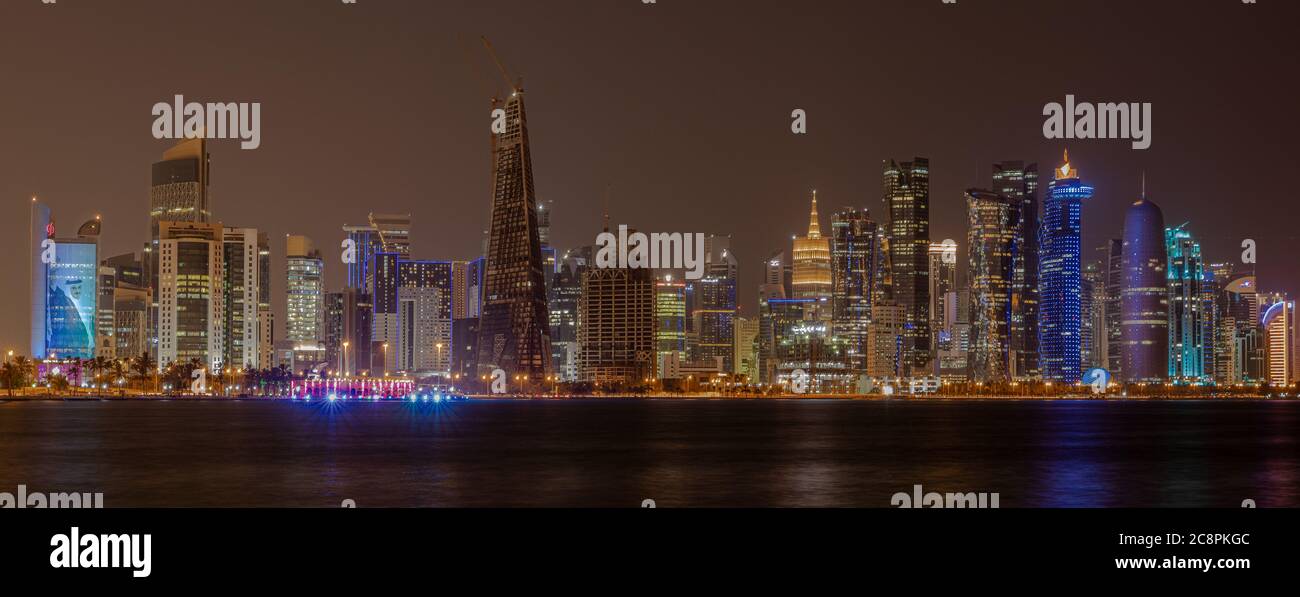 Doha Qatar skyline at night montrant les lumières des gratte-ciel reflétées dans le golfe Arabe Banque D'Images
