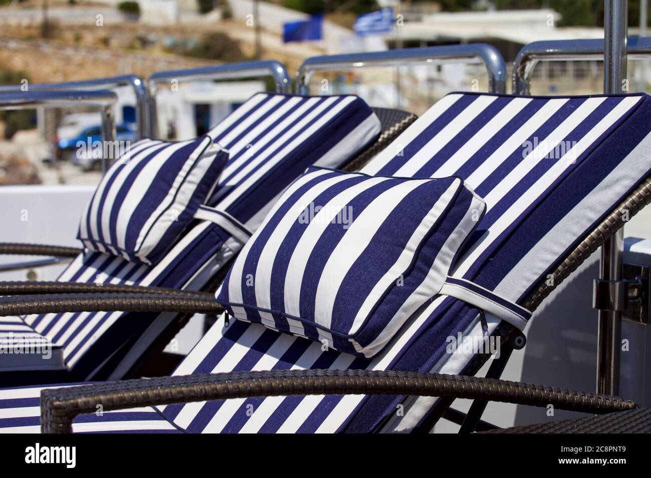 Transats de luxe. Isolé. Chaises longues rayées bleues et blanches sur le pont de yacht. Mise au point à l'avant. Image de stock. Banque D'Images