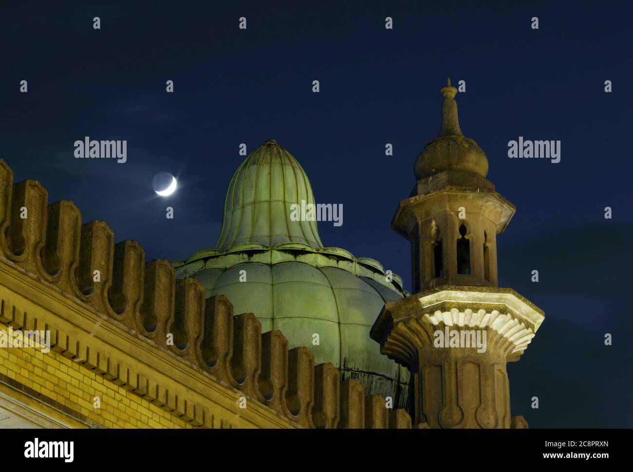 Un dôme à oignon et un minaret sur le dôme de Brighton, avec une nouvelle lune en arrière-plan. Banque D'Images