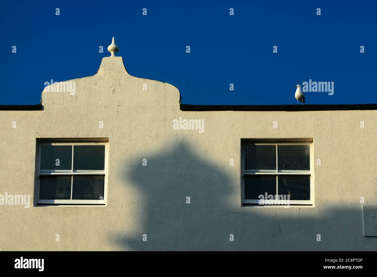 Un petit dôme ogee projette une ombre sur un mur avec un pignon de forme similaire, Western Road, Hove. Banque D'Images