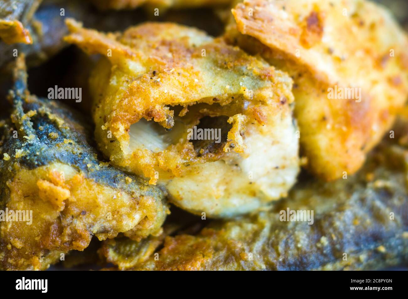 Morceaux de poisson navaga en pâte, frits dans l'huile dans une casserole. Banque D'Images