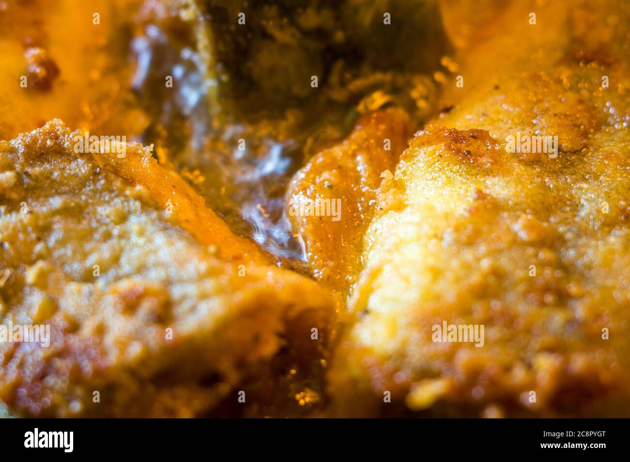Morceaux de poisson navaga en pâte, frits dans l'huile dans une casserole. Banque D'Images