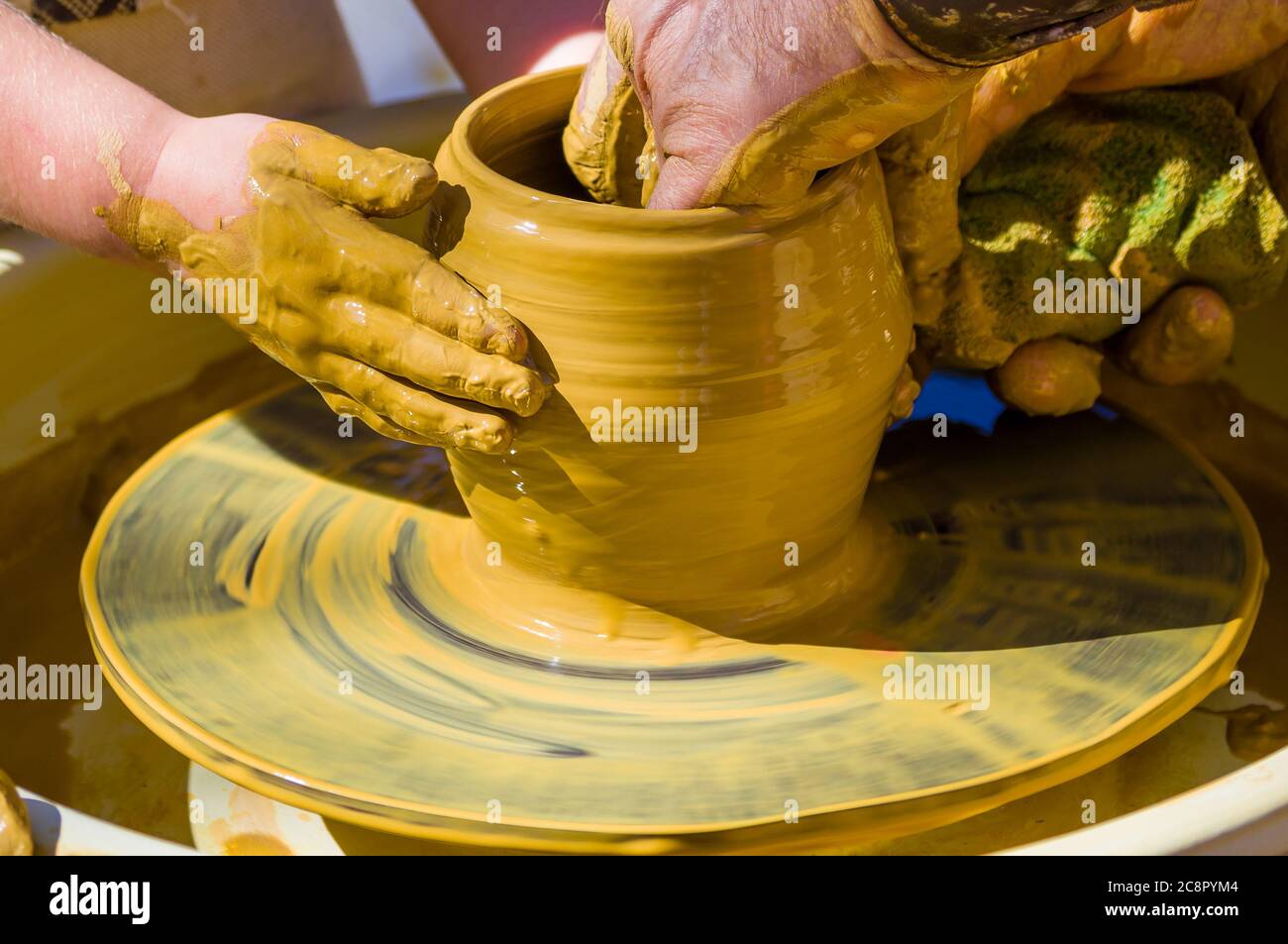 Les mains du maître potier et les mains des enfants, la formation de l'enfant à la production de poterie sur une roue de potier Banque D'Images