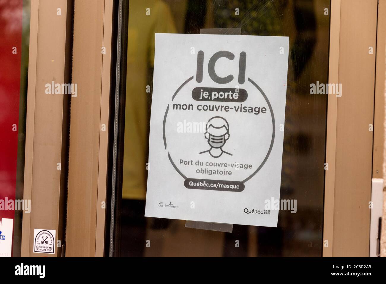 Montréal, CA - 26 juillet 2020 : une signalisation indiquant que des masques ou des revêtements non médicaux sont requis pour entrer dans le magasin Banque D'Images