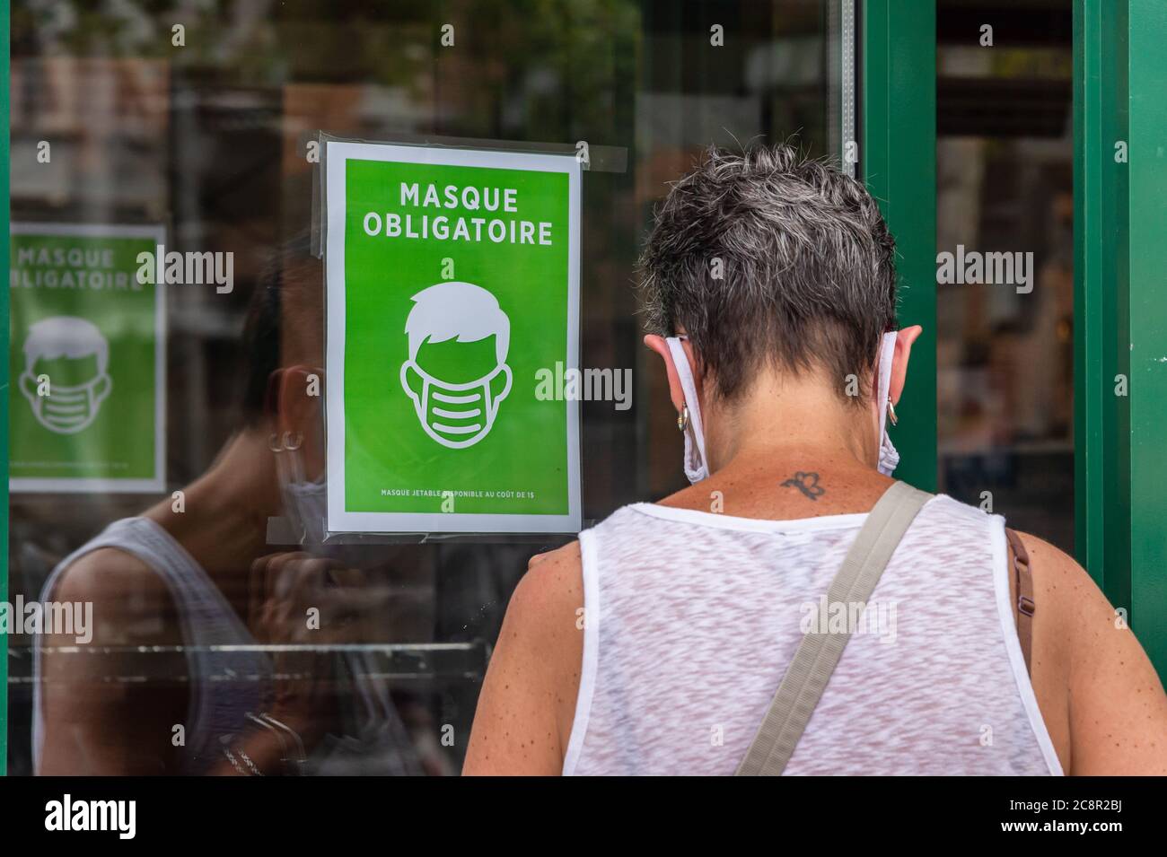 Montréal, CA - 26 juillet 2020 : une signalisation indiquant que des masques ou des revêtements non médicaux sont requis pour entrer dans le magasin Banque D'Images Montréal, CA - 26 juillet 2020 : une signalisation indiquant que des masques ou des revêtements non médicaux sont requis pour entrer dans le magasin Banque D'Images