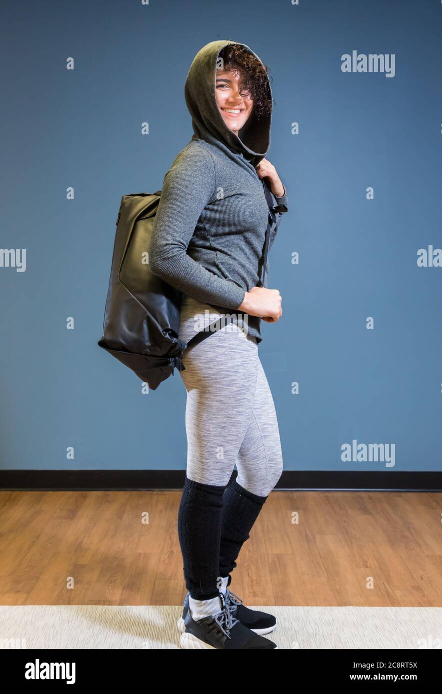 Jeune femme vêtue de vêtements de fitness avec sac sur l'épaule Banque D'Images