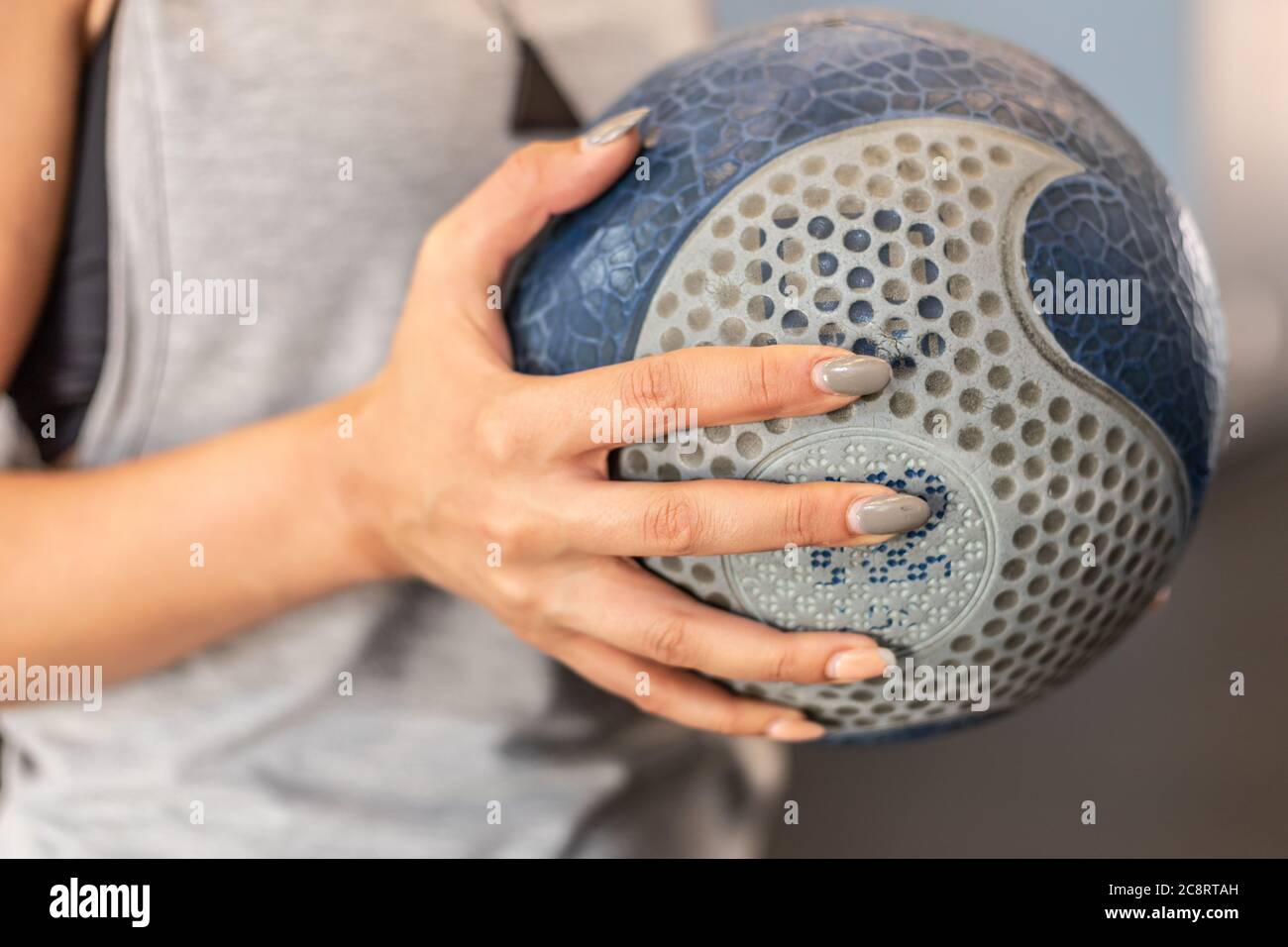 Une jeune femme s'entraîne dans une salle de sport avec des poids et des balles Banque D'Images