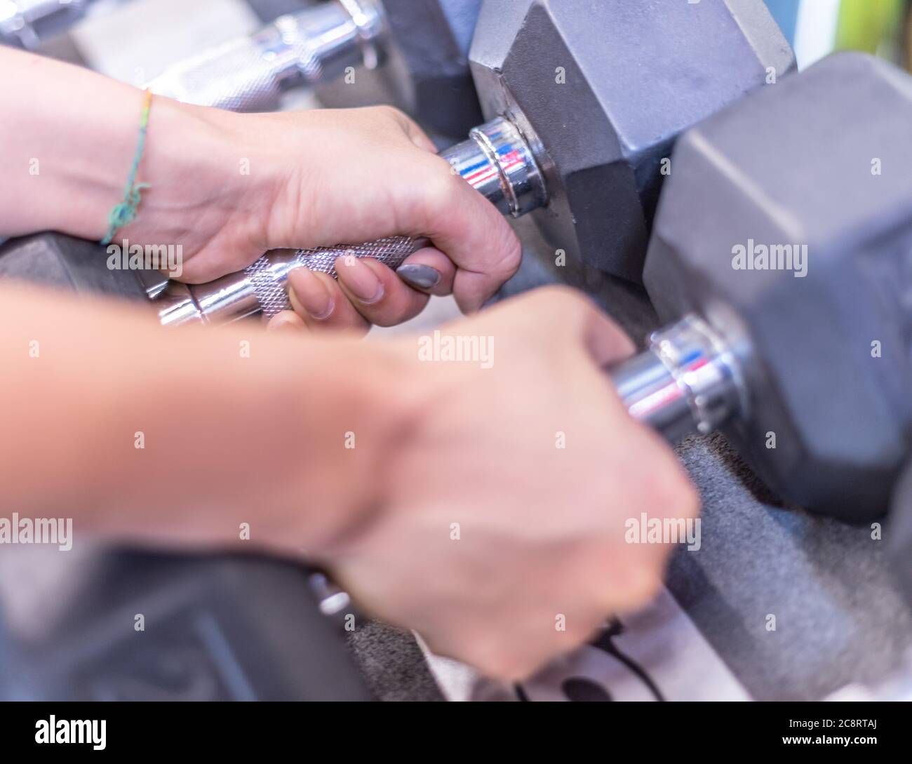 Une jeune femme s'entraîne dans une salle de sport avec des poids et des balles Banque D'Images
