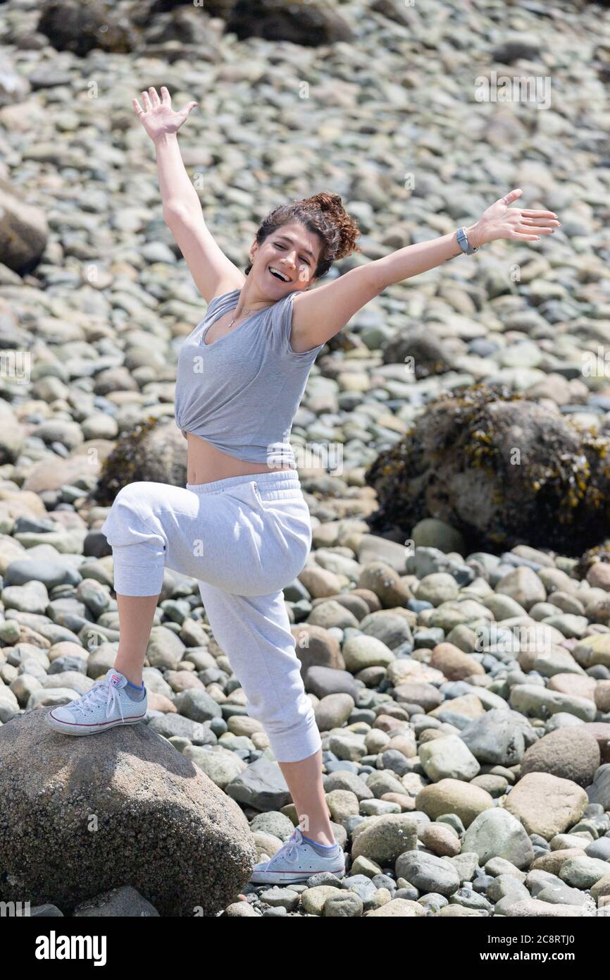 Jeune femme profitant d'une journée ensoleillée à la plage Banque D'Images