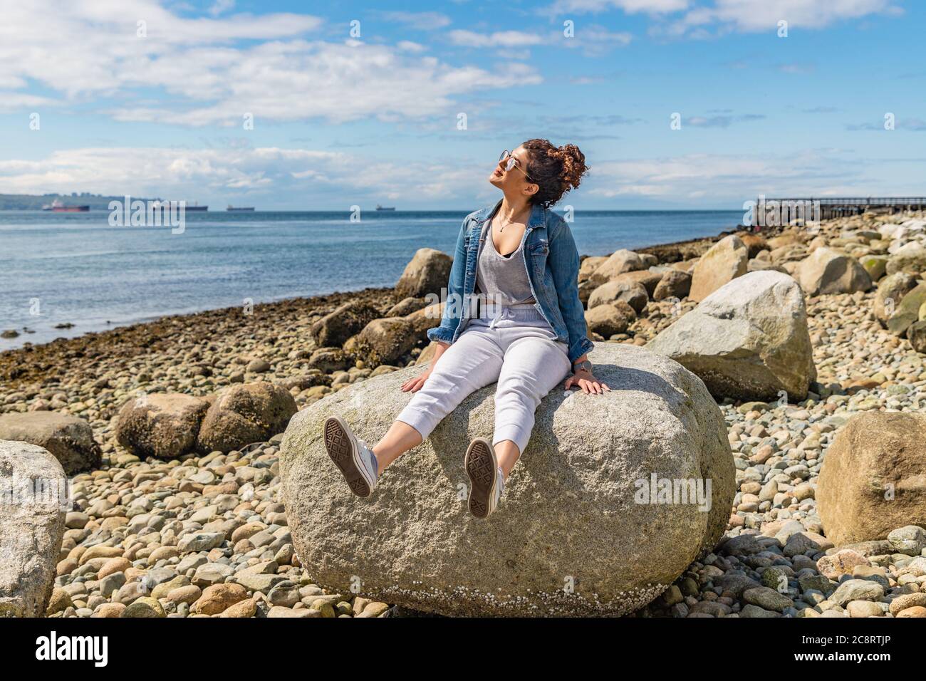 Jeune femme profitant d'une journée ensoleillée à la plage Banque D'Images