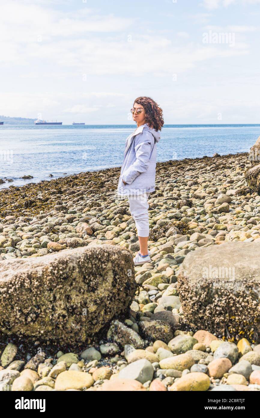 Jeune femme profitant d'une journée ensoleillée à la plage Banque D'Images