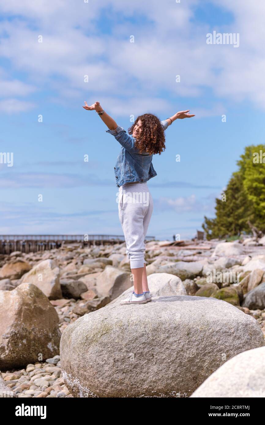 Jeune femme profitant d'une journée ensoleillée à la plage Banque D'Images