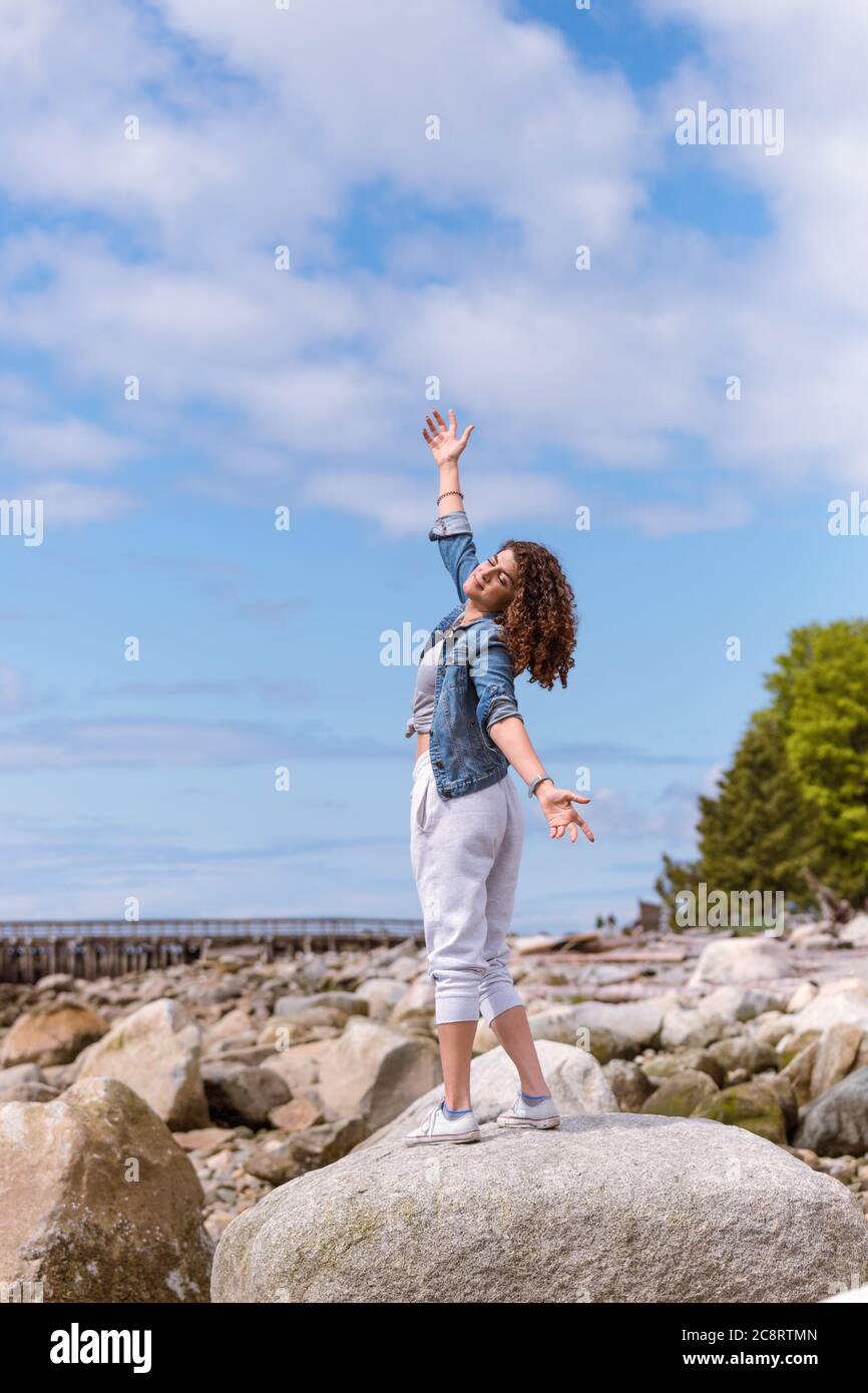 Jeune femme profitant d'une journée ensoleillée à la plage Banque D'Images