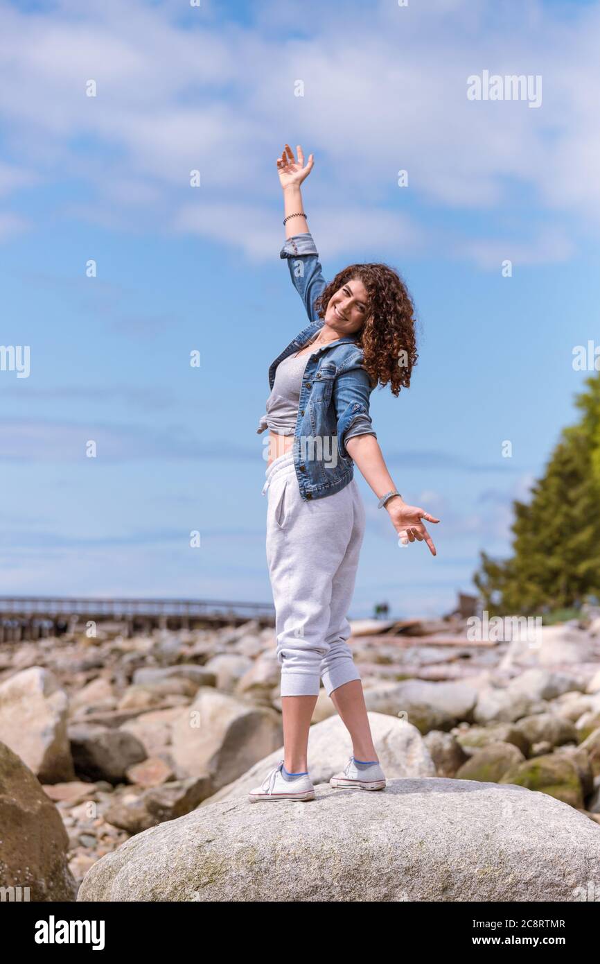 Jeune femme profitant d'une journée ensoleillée à la plage Banque D'Images