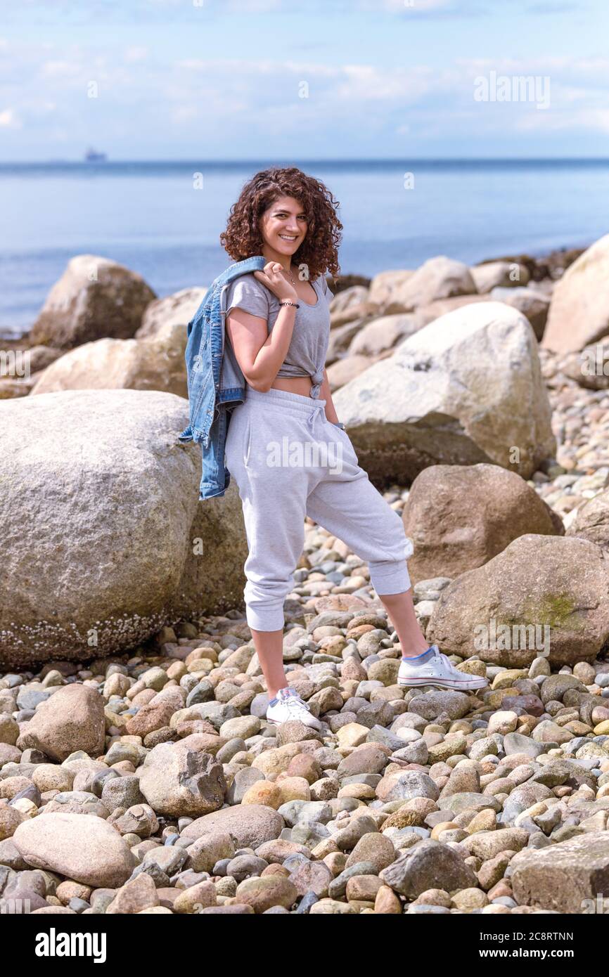 Jeune femme profitant d'une journée ensoleillée à la plage Banque D'Images