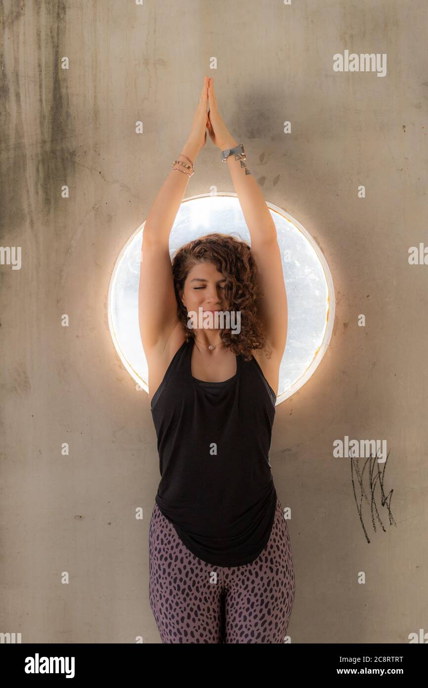 Jeune femme devant une fenêtre ronde Banque D'Images