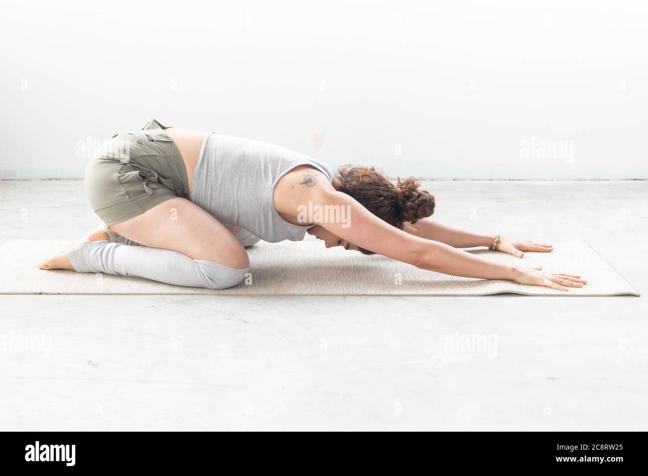 Un entraîneur de fitness s'étire en studio Banque D'Images