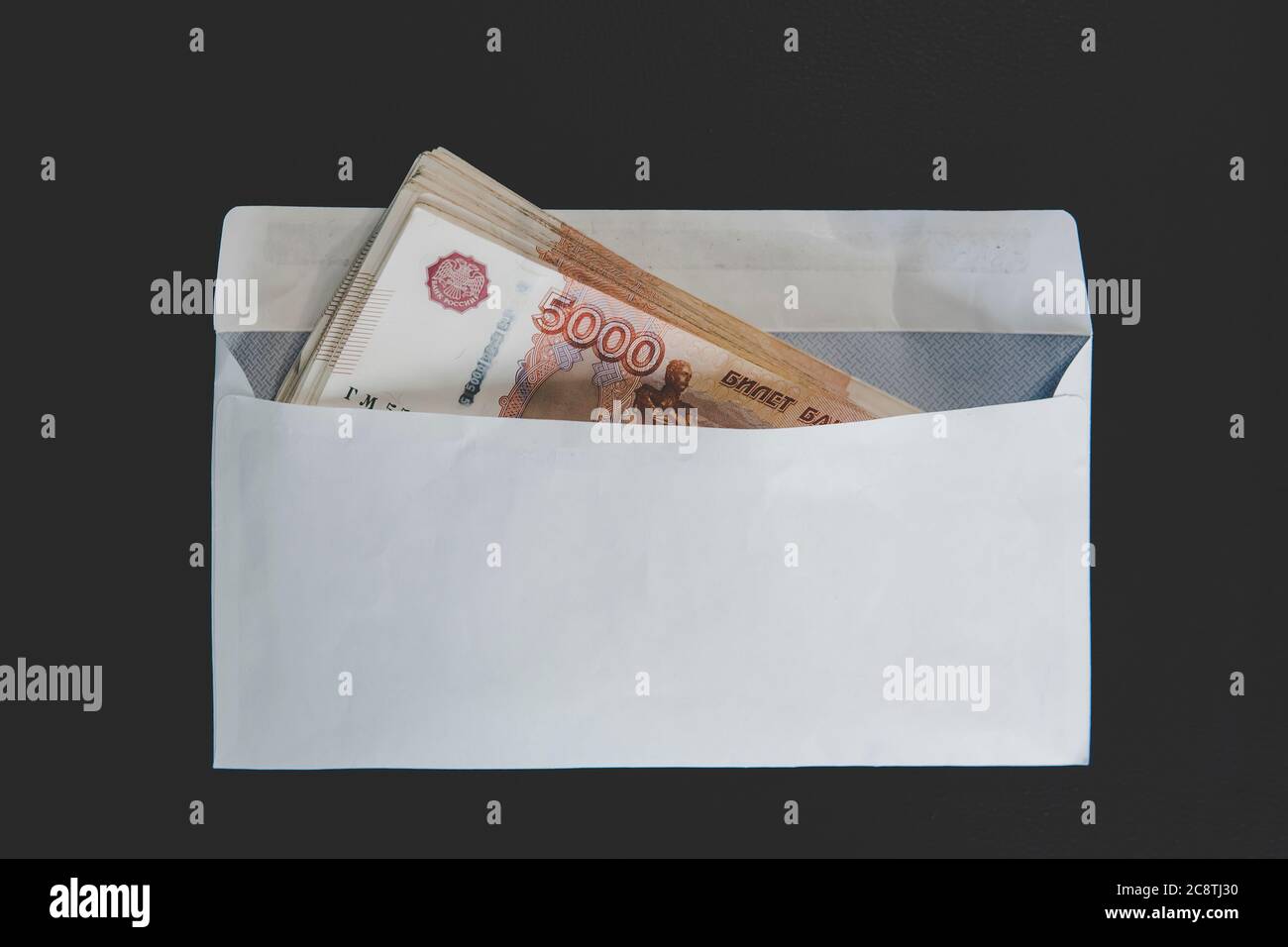 Grandes dénominations de 5000 roubles dans une enveloppe blanche. Main d'homme tient une enveloppe avec de l'argent. Le concept de corruption Banque D'Images
