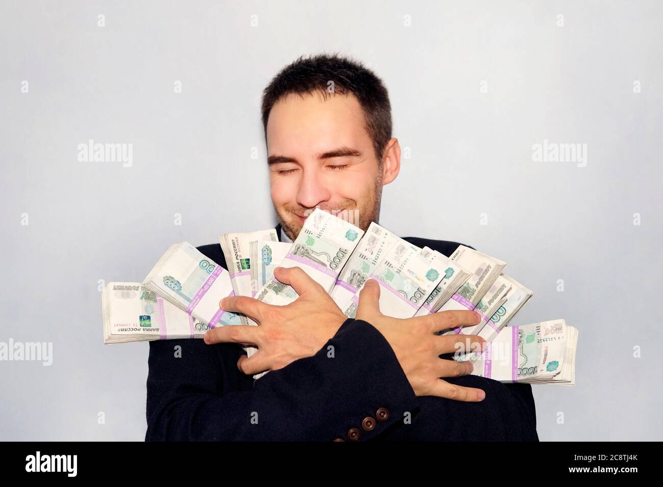armful d'argent dans les mains d'un jeune entrepreneur. Roubles par paquets. Millions de roubles. Le gagnant de la loterie. Homme d'affaires joyeux. L'argent a chuté Banque D'Images