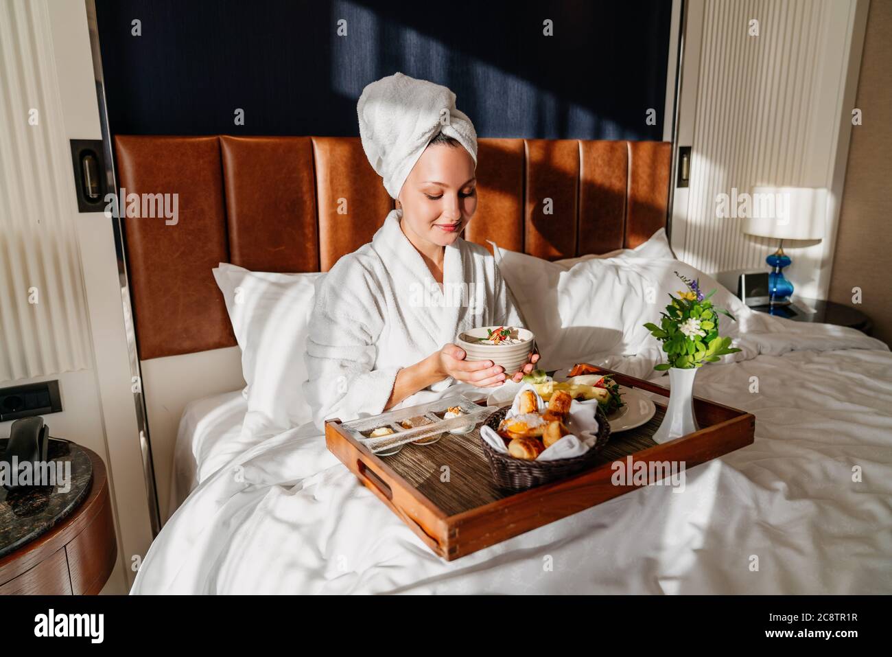 belle femme appréciant son petit déjeuner dans un lit confortable. Concept de service d'étage de l'hôtel. Photo de haute qualité Banque D'Images