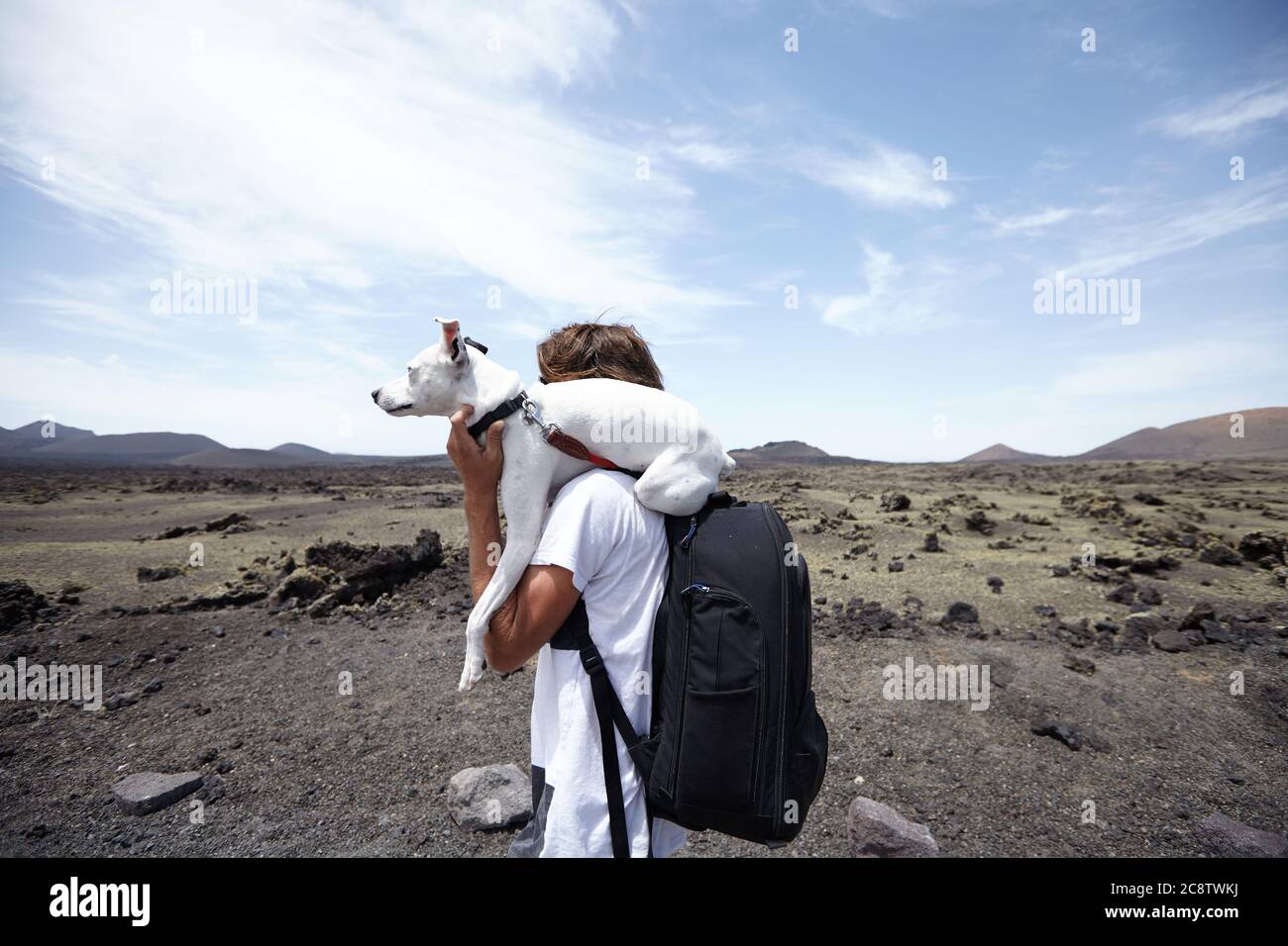 Chien et son propriétaire marchant sur la route du volcan à Lanzarote Banque D'Images
