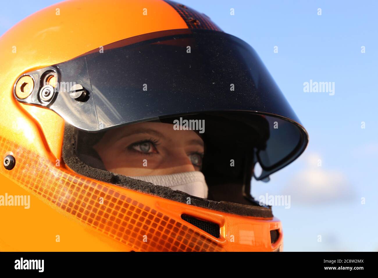 Image symbole : le pilote de voiture de course féminin porte un casque et une balaclava (modèle sorti) Banque D'Images