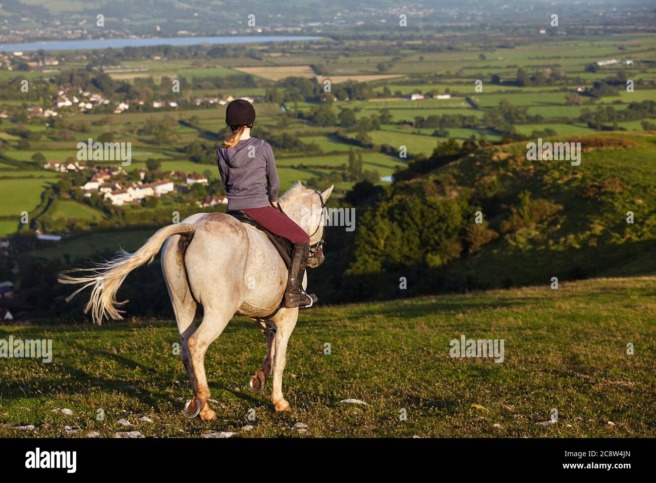 Un cavalier sur Crook Peak, dans les collines de Mendip, avec une vue sur les niveaux de Somerset au-delà, Somerset, Grande-Bretagne. Banque D'Images
