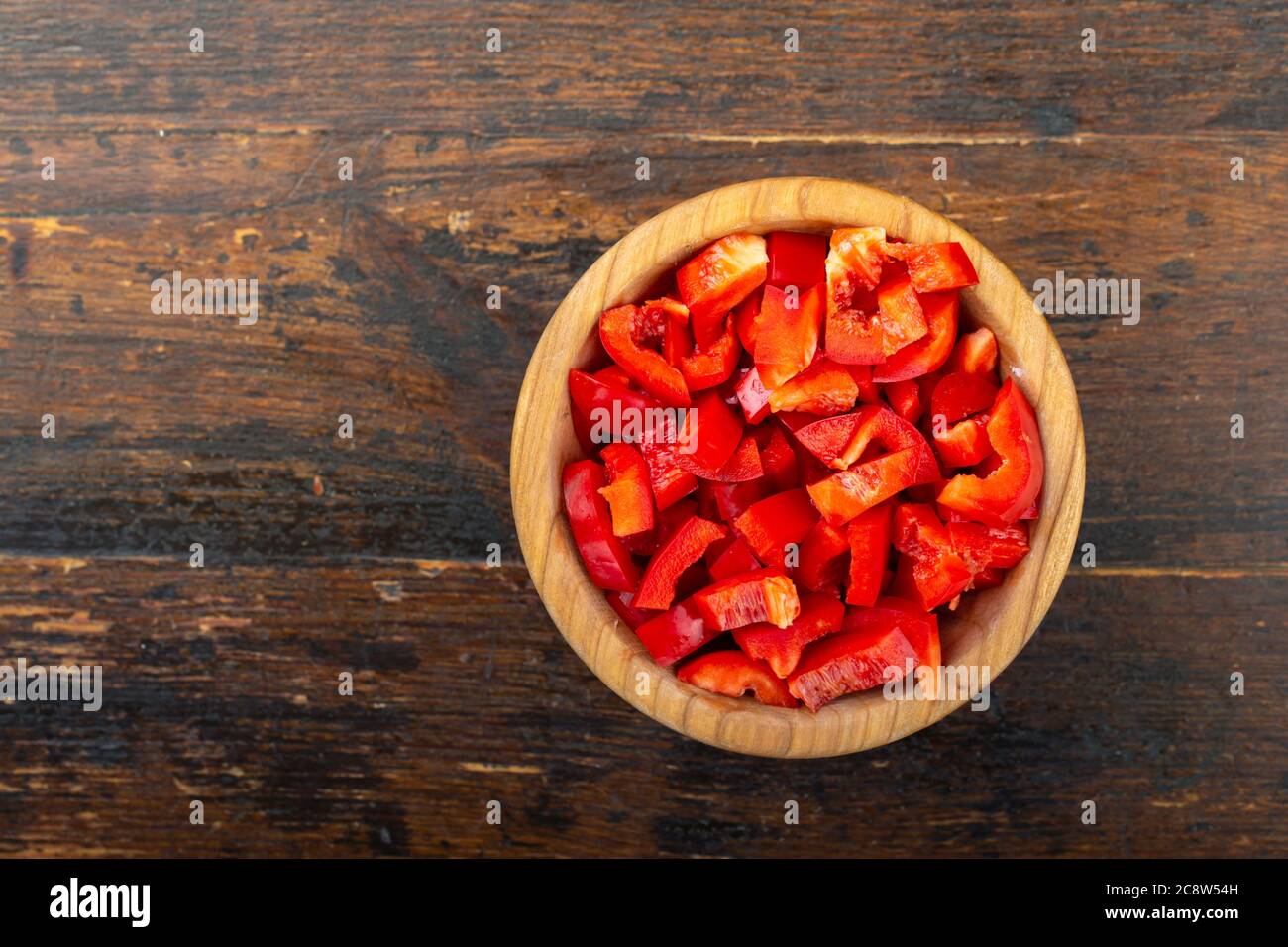 Émincé de poivron rouge brut dans un bol sur fond de bois. Légumes, ingrédients et aliments de base. Nourriture utile. Banque D'Images