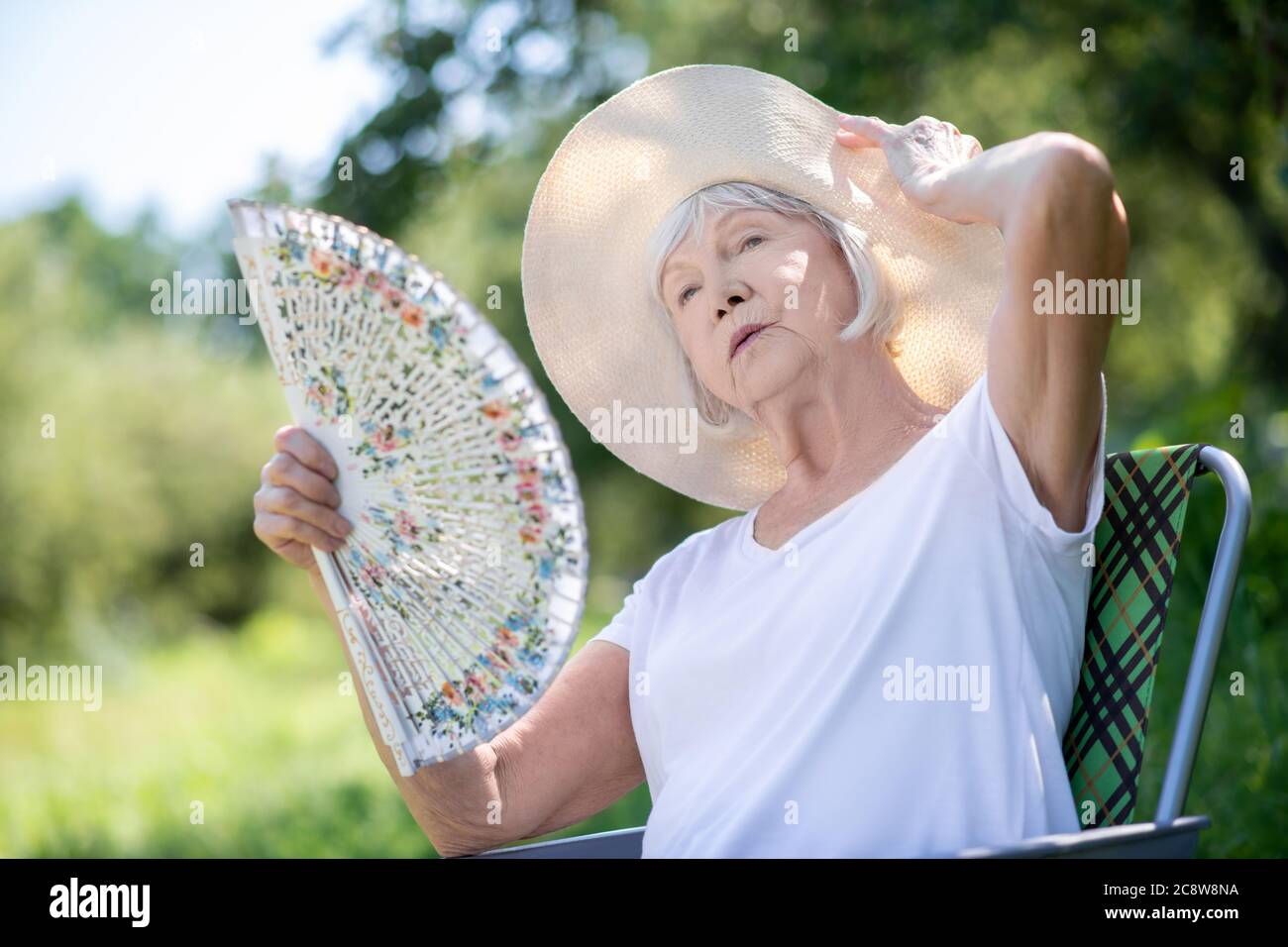 Femme dans un ventilateur de chaise Banque de photographies et d'images à  haute résolution - Alamy