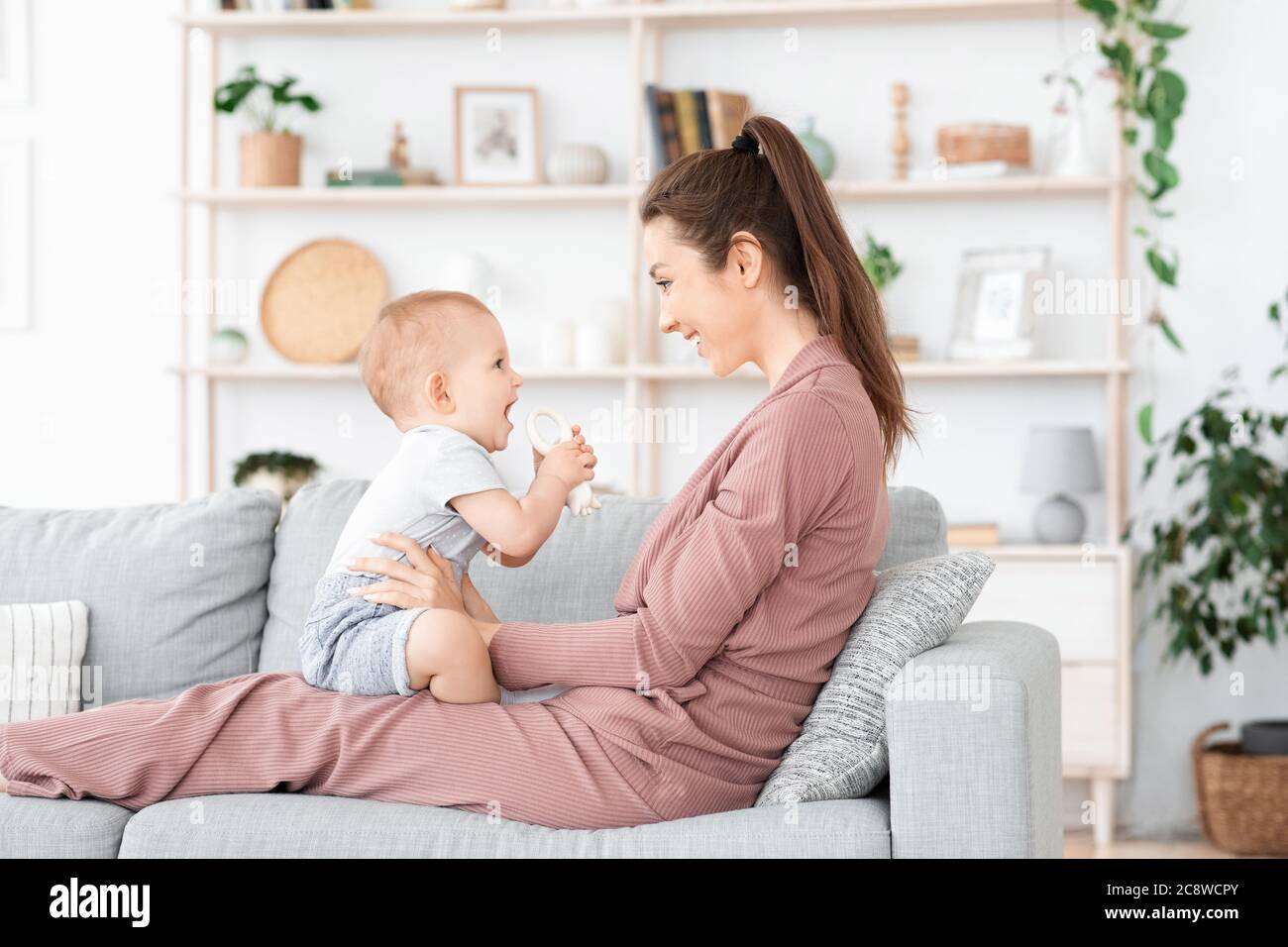 Famille heureuse et aimante. Mère et son bébé garçon jouant à la maison Banque D'Images