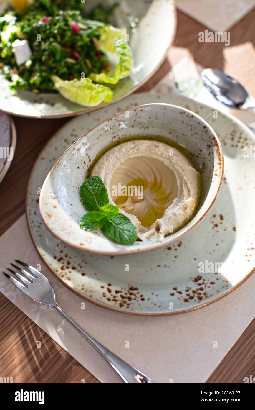 Hors-d'œuvre traditionnel du Moyen-Orient, houmous servis avec de la menthe fraîche Banque D'Images