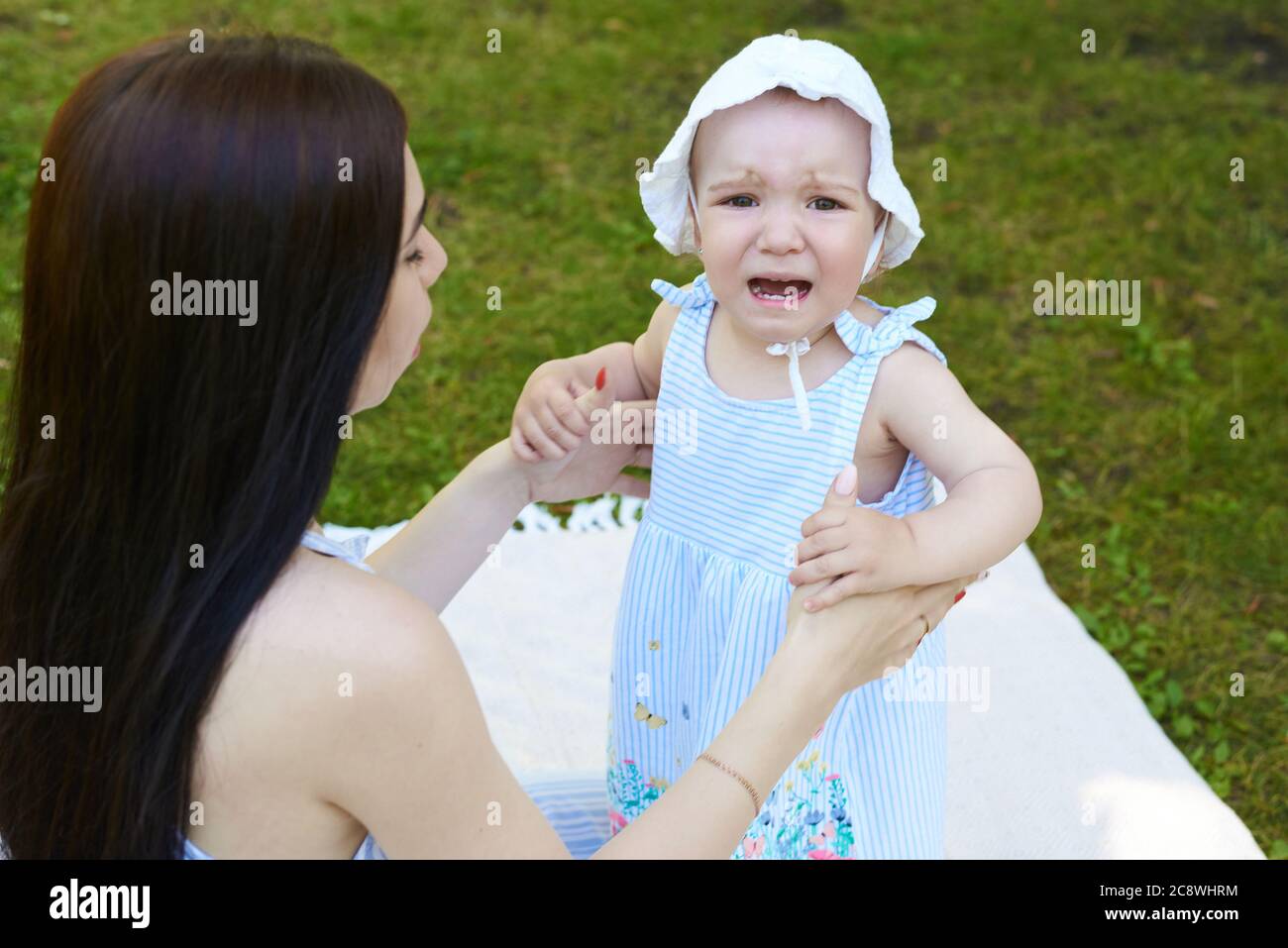 Un bébé pleure. La mère apaise sa fille. Banque D'Images