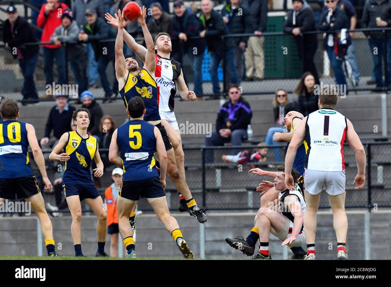 Nick Warnock de Benalla Saints tente de pousser le football des mains de son adversaire Mansfield lors d'un match de football à Victoria, en Australie Banque D'Images