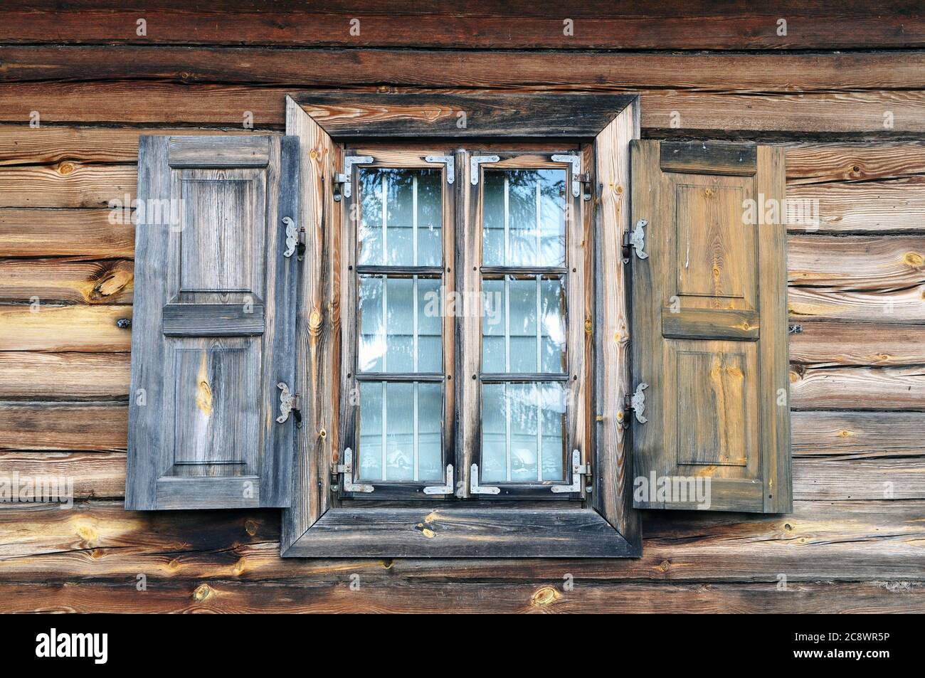 Une fenêtre avec volets dans une ancienne maison de campagne. Murs de maison en bois naturel avec fenêtre. Banque D'Images