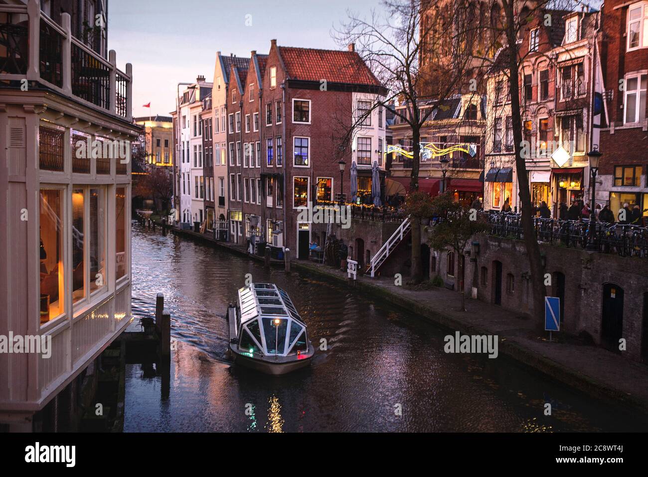 UTRECHT, PAYS-BAS - 25 novembre 2016 : les célèbres canaux et remblais de la ville d'Utrecht au coucher du soleil. Un bateau navigue dans le paysage urbain et le tradi Banque D'Images