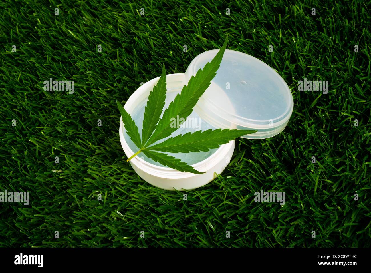 crème de cannabis sur l'herbe verte, soins de beauté de peau. Banque D'Images