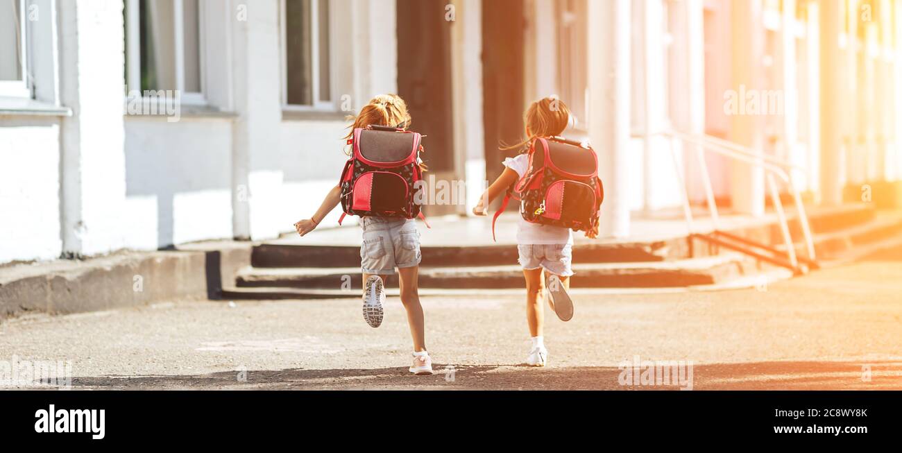 Deux écolières se tenant les mains de l'autre vont à l'école, à l'école, à l'enseignement primaire des enfants Banque D'Images