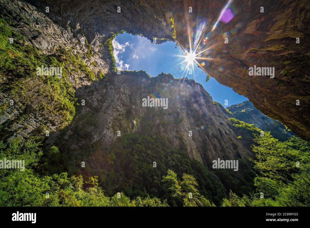 Soleil brillant à travers l'arche rocheuse naturelle et le paysage karstique du parc national de la fissure de Longshuixia, pays de Wulong, Chongqing, Chine Banque D'Images