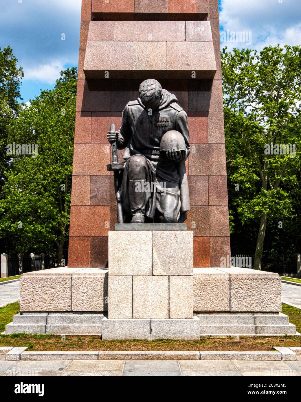 Sculpture de soldat à genoux en bronze devant un drapeau abstrait en granit au Mémorial de la guerre soviétique à Treptow Park, Berlin, Allemagne Banque D'Images