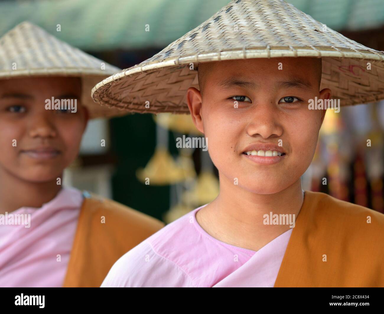 Deux jeunes religieuses bouddhistes birmanes avec des chapeaux coniques asiatiques. Banque D'Images